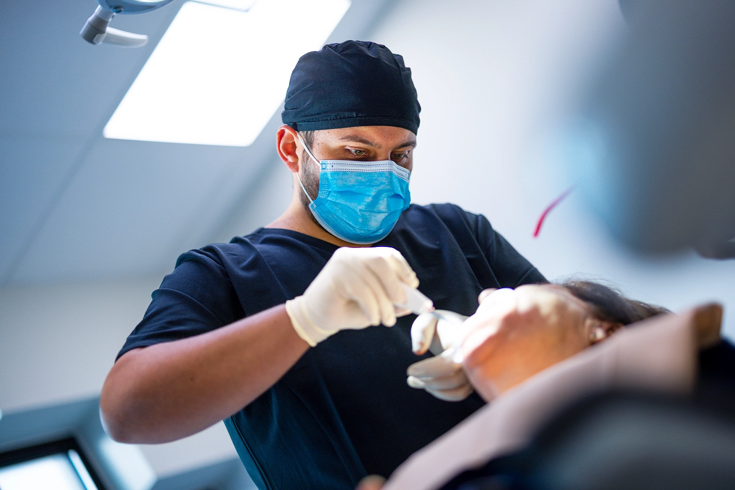 Dr Alex Fneiche en chirurgie, posant un implant dentaire guidé